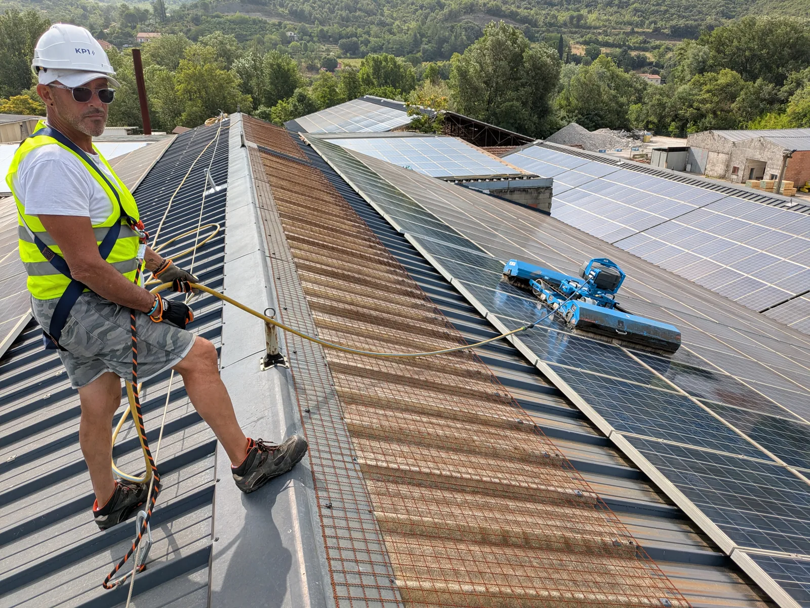 Technicien PureWatts en sécurité sur toiture avec robot de nettoyage